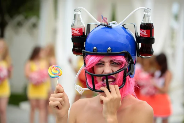 Woman in american football drink helmet