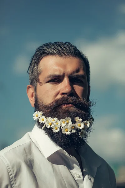 Handsome man with flowers in beard