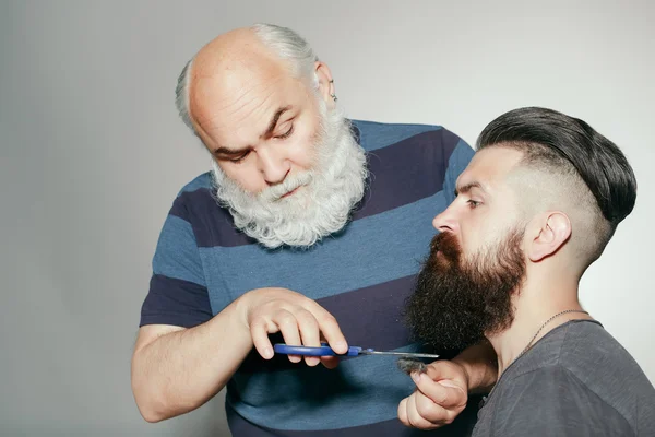 Old hairdresser and young bearded man