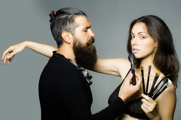 Visagiste bearded man and sexy woman