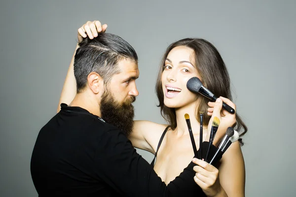 Visagiste bearded man and sexy woman