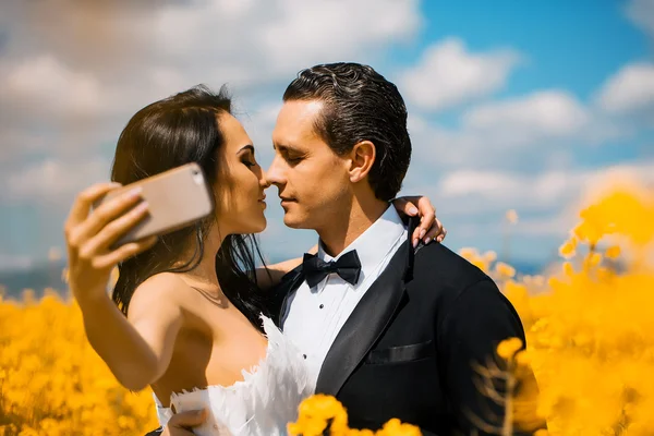Wedding couple kiss in field yellow flowers