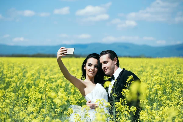Wedding couple in field yellow flowers