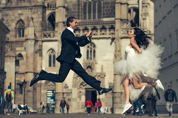 Wedding happy couple jumping near castle