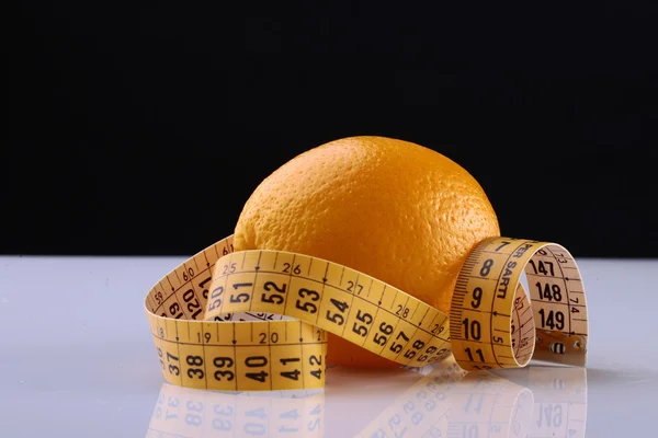 Orange fruit and measuring tape