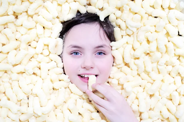 Little girl with blue eyes in corn sticks