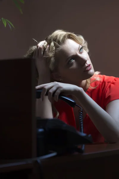 Pensive female secretary with phone