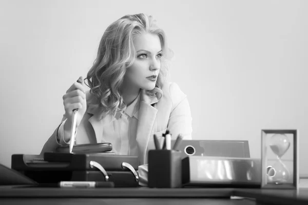 Pensive woman with paper knife in office