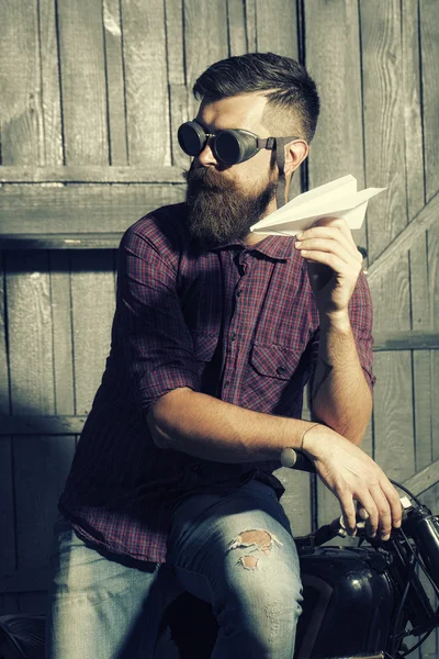 Man in glasses holding paper plane