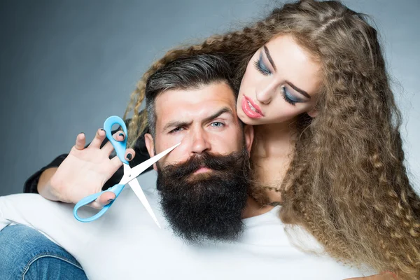 Woman cutting man\'s beard