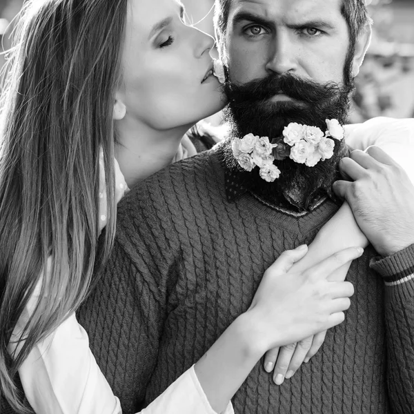 Girl and man with flowers on beard