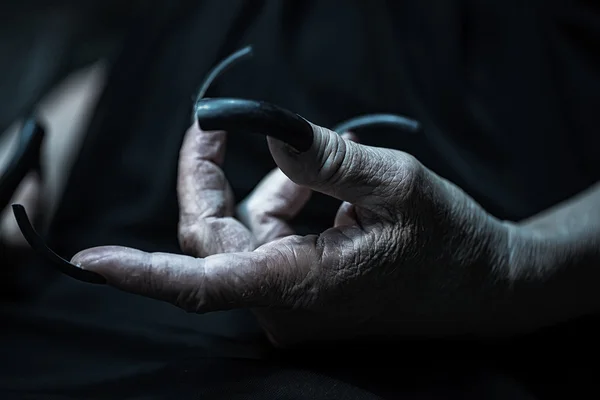 Wrinkled hand with long fingernails
