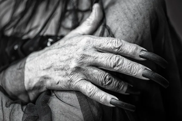 Wrinkled hand with long fingernails
