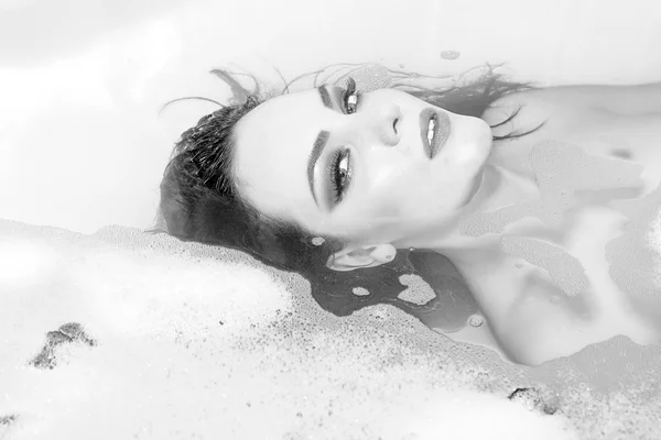 Woman lying in bath