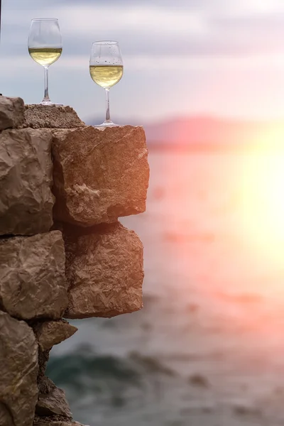 Two wine glasses on stone