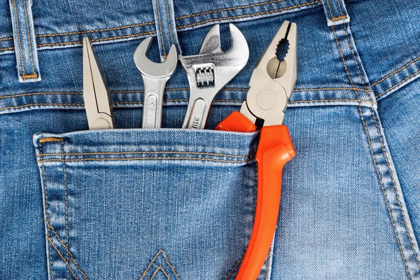 Toolkit of four items in a blue jeans pocket
