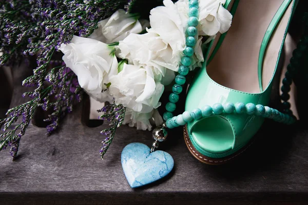 Green female shoes, flowers and necklace