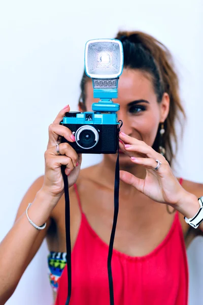 Woman focusing at you with her old-fashioned camera