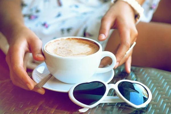 Woman holding cup of her morning cappuccino