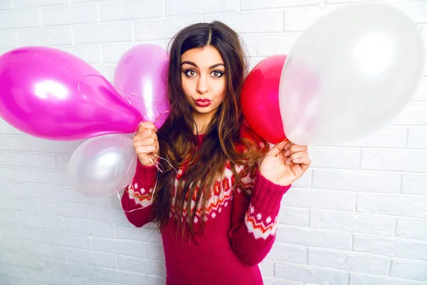 Brunette girl holding party balloons