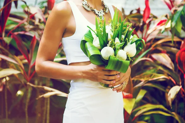 Slim woman holding wedding bouquet