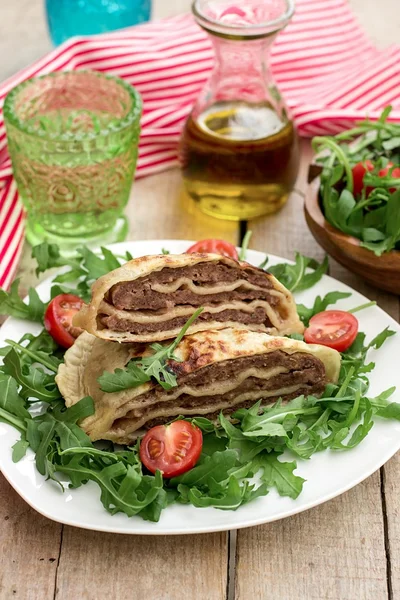 Layered meat pies with green salad