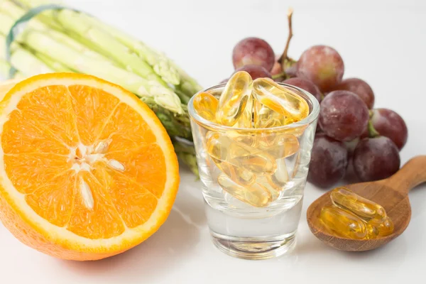 Vitamin Capsules with fruit on white