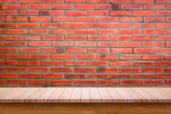 Empty wooden table with red brick wall background.