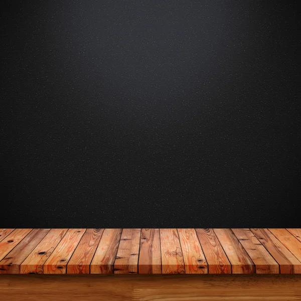 Empty top of wooden table on black gradient background.