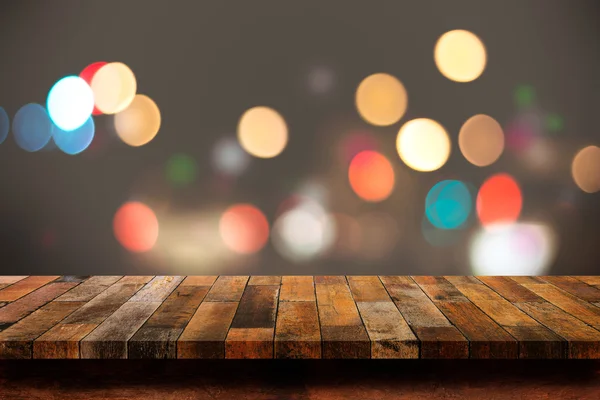 Empty wooden table with bokeh abstract light background.