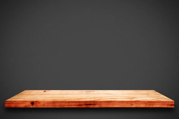 Empty wooden shelf on black gradient background.