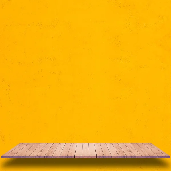 Empty wooden shelf with yellow wall background.