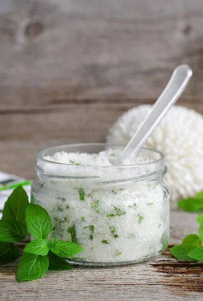 Refreshing homemade sugar scrub with vegetable oil, chopped mint and essential mint oil