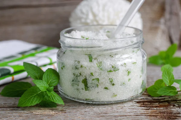 Refreshing homemade sugar scrub with vegetable oil, chopped mint and essential mint oil