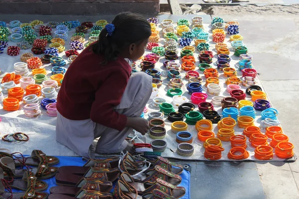 Young Indian girl selling shoes and bangles in the street of Jaipur