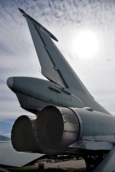 The tail of the plane against the sky and sunlight