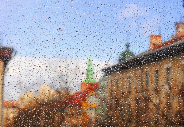 Municipal landscape through the window with rain drops