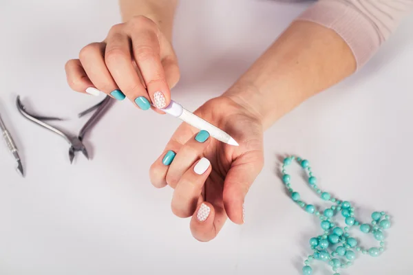 Beautiful manicure. gel polish coating in white and turquoise, stamping.