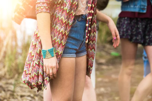 Young girl in denim shorts, jewelry accessories.