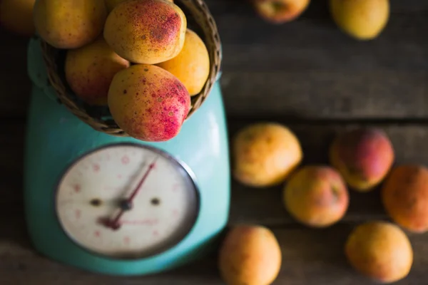 Apricots with kitchen scales on a wood background. toning. Vegetarian food. Healthy life.