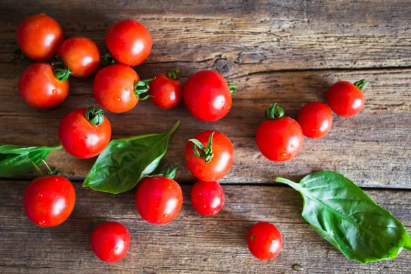 Fresh grape tomatoes with basil and coarse salt for use as cooking ingredients