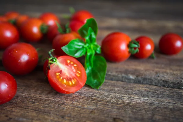 Fresh grape tomatoes with basil and coarse salt for use as cooking ingredients