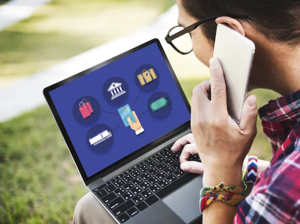 Man using digital devices, surfing the internet on laptop and speaking on the phone