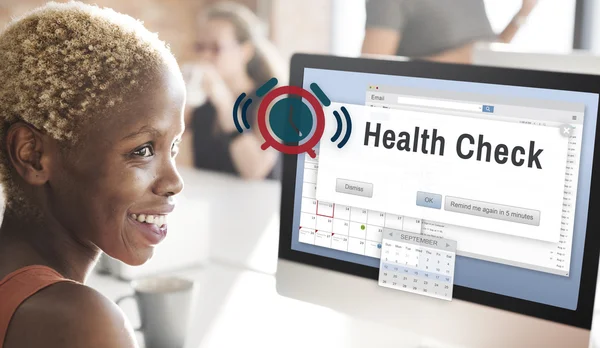 Businesswoman working on computer with health check