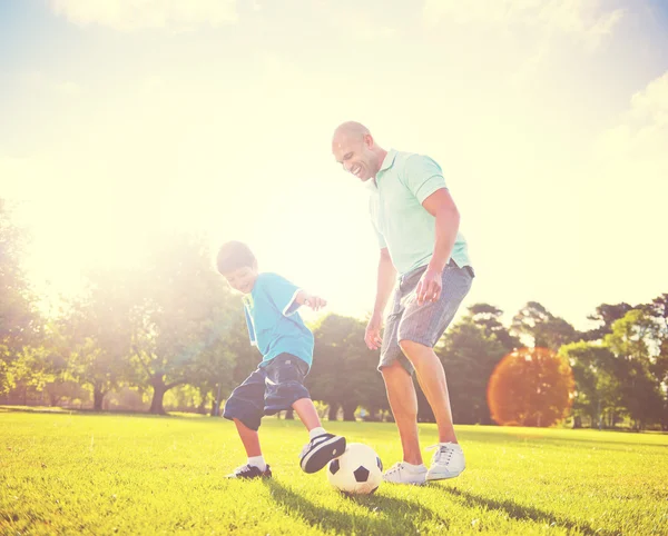 Father playing football with little son