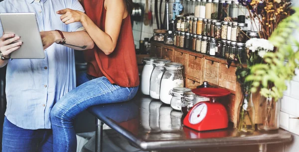 Couple in kitchen with  digital device