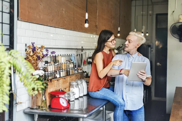 Couple in kitchen with  digital device