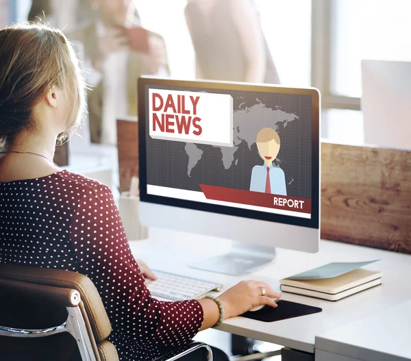 Businesswoman working on computer with daily news