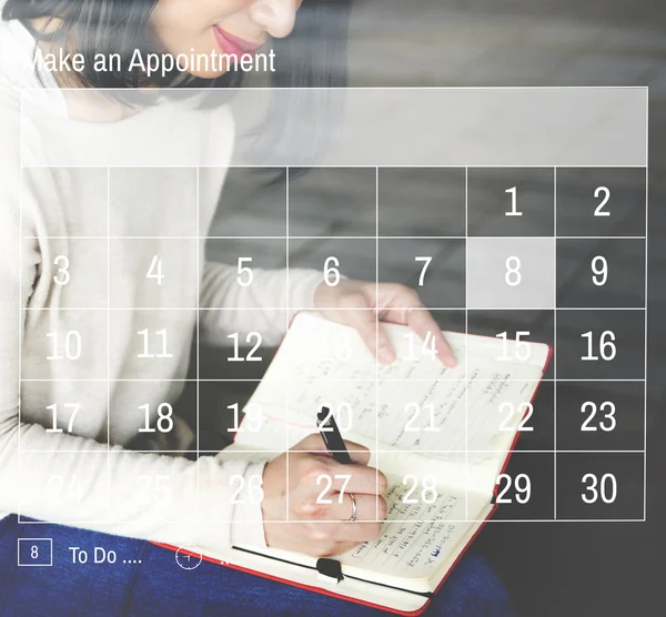 Woman writing in notebook with calendar