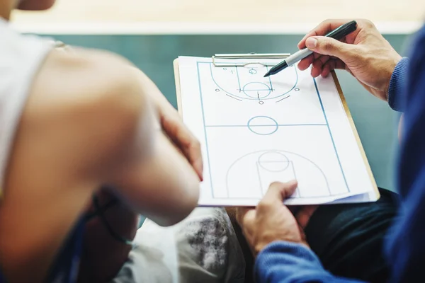 Sportsman teaching boy play Basketball